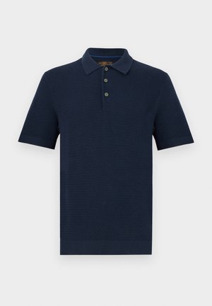 Tmavě modrá pletená polokošile s krátkým rukávem, tříknoflíková legrační léga a žebrovaný límec, manžety a spodní lem, zobrazena na bílém pozadí.