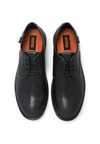 Schwarze Lederschuhe mit glatter Oberfläche, runder Zehenform, Schnürdesign und orangefarbener Innensohle. Mit schwarzem Branding auf der Zunge und Ferse.