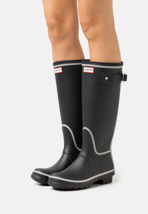 Botas de lluvia de goma negras con detalles grises, que cuentan con un hebilla, suela resistente y punta redonda. Logo mostrado en la parte superior.