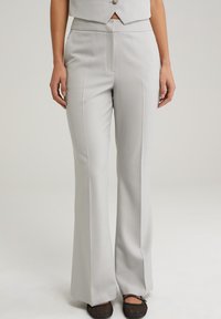 Pantalones de corte recto en color gris claro, confeccionados en una tela suave, con pliegues frontales y una cintura de altura media.