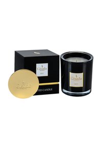 Bougie en verre noir avec un couvercle et une étiquette dorés, présentée dans une boîte noire assortie. Présente la marque "Gisada" et les détails du parfum "Iris".