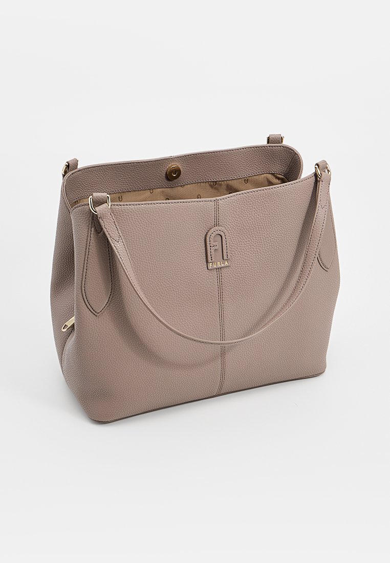 Jasnobeżowa skórzana torebka o fakturze drobnoziarnistej, z zaokrąglonym kształtem, podwójnymi uchwytami i markowym logo z przodu.