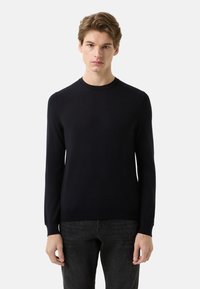 Granatowy sweter z okrągłym dekoltem i długimi rękawami, wykonany z miękkiego materiału. Dopasowany krój z prążkowanymi mankietami i paskiem na dole. Gładkie wykończenie bez ozdób.