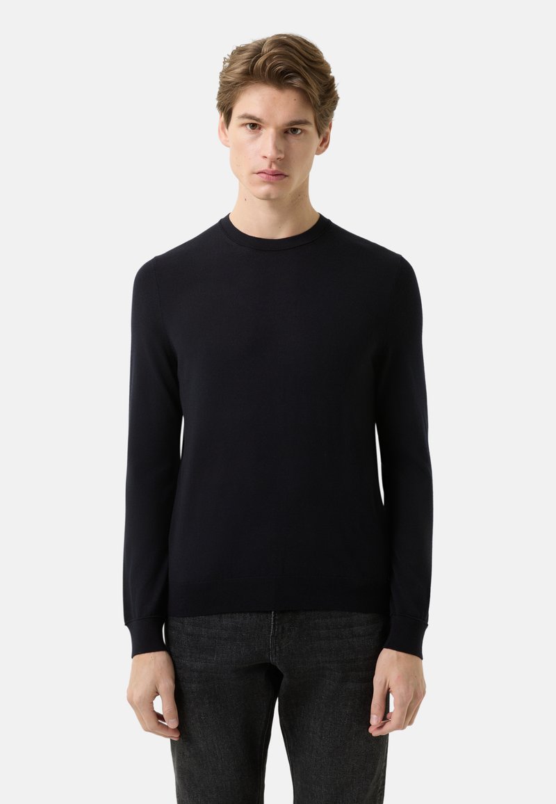 Granatowy sweter z okrągłym dekoltem i długimi rękawami, wykonany z miękkiego materiału. Dopasowany krój z prążkowanymi mankietami i paskiem na dole. Gładkie wykończenie bez ozdób.