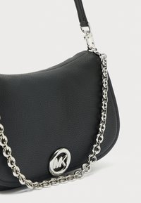 Zwart gestructureerde leren handtas met zilveren kettingriem en zilveren MK rond logomerk op de voorflap.