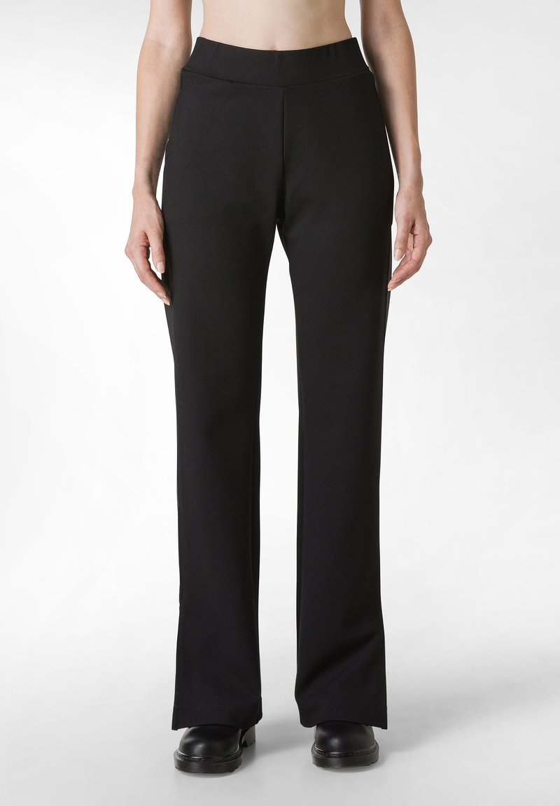 Pantaloni neri a gamba larga realizzati in tessuto elasticizzato, dotati di un alto punto vita, texture liscia e design minimalista. Cuciture piatte e senza tasche.