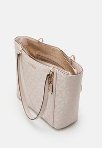 Lichtroze gewatteerde shopper met goudkleurige afwerking, dubbele bovenhandvatten en een ritssluiting. Binnenzijde heeft een patroonvoering en meerdere vakken.