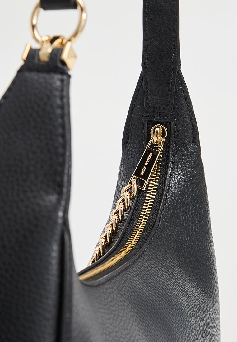 Borsa in pelle nera con finitura testurizzata, zip dorata con dettaglio a catena e una tracolla sottile e piatta.