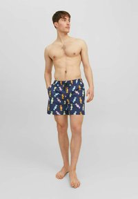 Pantaloni da bagno blu navy con un motivo di caramelle colorate, realizzati in tessuto leggero, dotati di vita elastica e tasche laterali.
