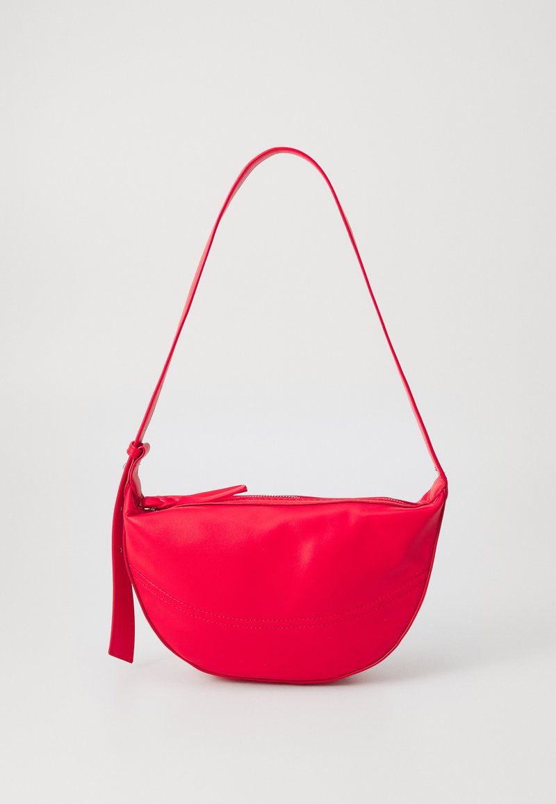 Red leather shoulder bag with a curved shape, a zippered closure, and a thin adjustable strap. Smooth texture with seam detailing.