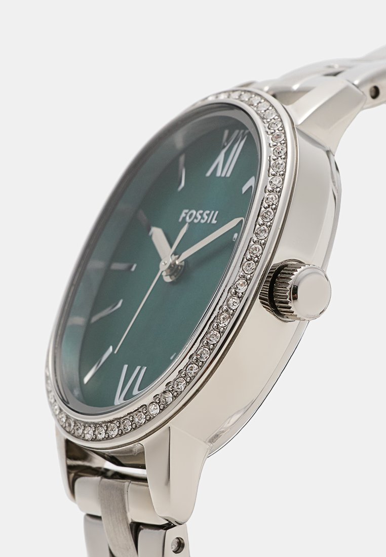 Silver fossil watch with a green dial, Roman numerals, and a crystal-accented bezel. Features a stainless steel bracelet and crown.