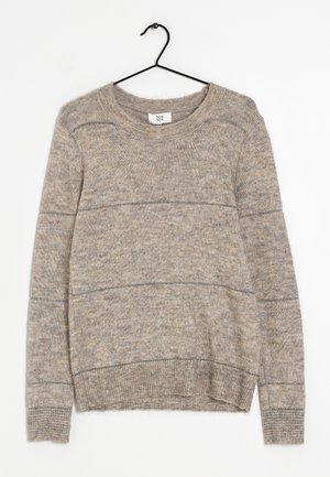 Lichtbruin gebreide trui met lange mouwen, geribbelde manchetten en zoom, hangend aan een zwarte hanger tegen een witte achtergrond.