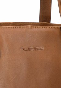 Braune Lederhandtasche mit glatter Textur und geprägtem "PLEVIER"-Logo. Das Design umfasst robuste Nähte und einen schlichten Stil.