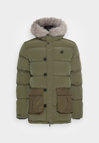 Oliven grøn pufferjakke med en faux fur hætte, frontknaplukning og to store lommere nederst, med en let blank tekstur.
