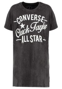 T-shirt noir oversize en coton, avec un grand texte blanc "CONVERSE Chuck Taylor ALL STAR" et un logo étoile. Manches courtes, col rond.