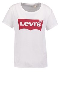 Camiseta blanca de algodón con un gran logotipo rojo de Levi's en una forma arqueada distintiva. Cuello redondo clásico y mangas cortas.