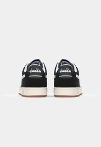Baskets en daim noir avec des accents bleu clair. Dotées d'une semelle en caoutchouc et d'un logo sur le talon, texture lisse et design classique à tige basse.