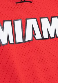 Rotes Mesh-Sporttrikot mit dem Schriftzug "MIAMI" in fetten weißen Buchstaben, umrissen in Schwarz. Der Stoff hat eine durchlässige Textur für bessere Atmungsaktivität.