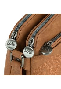 Bolso de cuero sintético marrón con dos cremalleras plateadas y tiradores circulares grabados con "Lois". Presenta un patrón decorativo en relieve en el lateral.