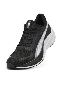 Schwarzer Sportschuh mit einem Obermaterial aus Mesh, ausgestattet mit einem silbernen Akzentstreifen, schwarzen Schnürsenkeln und einer dicken weißen Sohle. PUMA-Logo auf der Zunge.