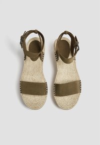 Sandales en daim marron avec une large sangle en tissu, semelle en corde de jute et quincaillerie en argent sur la sangle de cheville réglable ; design plat et surface texturée.