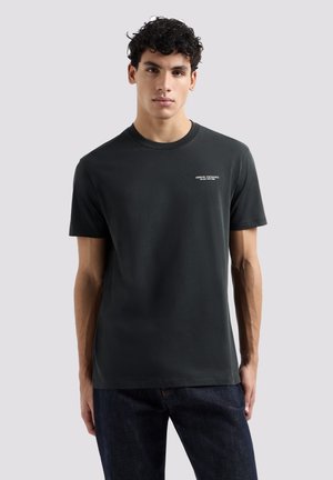 T-shirt nero in cotone con scollo rotondo, maniche corte e un piccolo logo bianco sul lato sinistro del petto. Tessuto morbido, vestibilità casual.