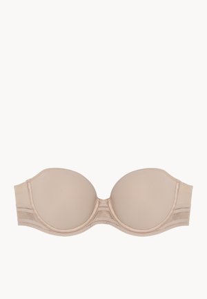 Soutien-gorge sans bretelles beige avec des bonnets lisses et rembourrés, présentant un léger éclat. Bande sous poitrine en tissu doux et texturé avec un soutien léger.