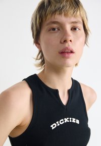 Zwarte geribbelde tanktop met een ronde halslijn en een kleine uitsparing aan de voorkant, met de witte "DICKIES" logo tekst over de borst.