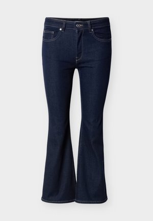 Σκούρο μπλε καμπανιστό τζιν από ντένιμ. Διαθέτει μπροστινές τσέπες, φερμουάρ εμπρός και διακριτικές ραφές κατά μήκος των ραφών.