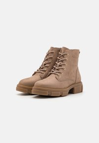 Bottines en suède marron avec un design à lacets, œillets en ton doré, col rembourré et semelle en caoutchouc épaisse avec une adhérence texturée.