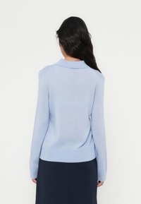 Ανοιχτό μπλε πλεκτό πουλόβερ με γιακά, ριμπ μανσέτες και στρίφωμα, με απαλή υφή και εφαρμοστή σιλουέτα.