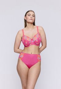 Roze geborduurde beha en een set van hoogzittende string, met bloemenpatronen, gegolfde randen en doorschijnende kantdetails op de cups.