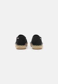 Espadrillas nere in tessuto canvas con suola in corda di juta e dettagli di cucitura accentuati. Presentano un retro basso e una marca minima di branding sul lato.