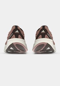 Adidas adizero sko med en rosa-brun mesh-overdel, svarte detaljer, hvit mellomsole og en teksturert gummisåle. Har logo-detaljer.