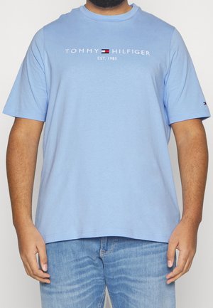 Hellblaues T-Shirt mit kurzen Ärmeln aus Baumwolle, mit dem aufgestickten "TOMMY HILFIGER"-Logo und "EST. 1985" in Weiß über der Brust.