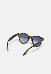 Ochelari de soare cat-eye cu un model de broască țestoasă, lentile cu gradient albastru și accente negre lucioase pe ramă. Prezintă detalii cu balamale din metal.