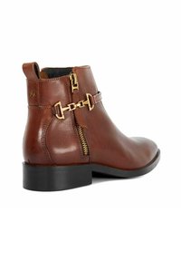 Bottine en cuir marron avec une texture lisse, fermeture éclair sur le côté et accent en chaîne dorée. Bout carré et petit talon noir.