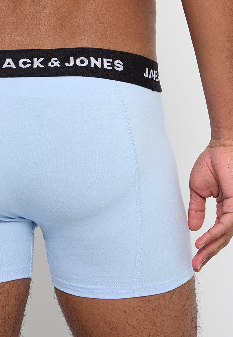 Bañador corto de color azul claro hecho de algodón, con una cinturilla elástica negra con el logotipo "JACK & JONES". Detalles de costura a lo largo de los bordes.