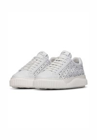 Sneaker bianche con suola in gomma testurizzata, caratterizzate da un design laterale perforato e lacci piatti. Marchio sulla linguetta e sul lato.