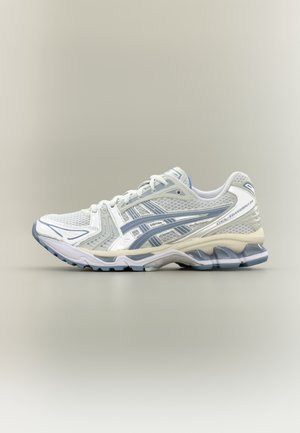 Chaussure de course blanche et bleu clair avec tige en mesh, bandes latérales à motifs et semelle amortie, vue de profil latéral.