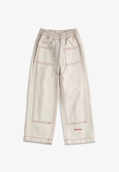 Pantalon beige à jambes larges avec coutures rouges, taille élastique, deux grandes poches avant, et "Bobo Choses" brodé près de l'ourlet.