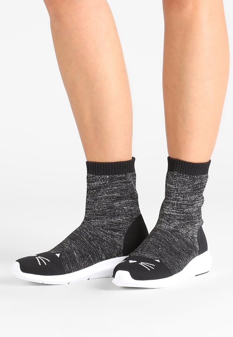 Schwarze und graue strukturierte Socken mit einem Katzengesicht-Design an der Spitze, mit einem engen Knöchellänge und einer weißen Gummisohle.