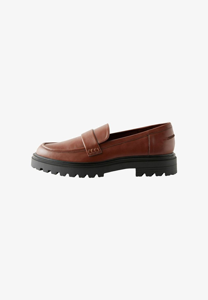 Brown leather loafers featuring a raised toe cap, decorative strap, and textured black rubber sole with prominent tread.