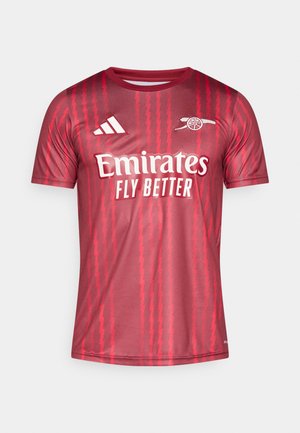 Maglia rossa a maniche corte con motivo a zigzag, logo Adidas sulla spalla sinistra e testo "Emirates Fly Better" in bianco.