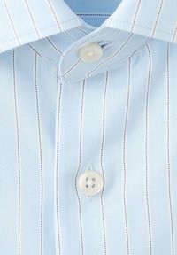 Tela de camisa a rayas azul claro con cierre de botón. Presenta rayas verticales en blanco y azul oscuro, textura suave, diseño de cuello clásico.