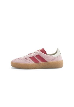 Baskets basses en daim rose avec des rayures rouges, des lacets blancs, une languette de talon blanche et une semelle en caoutchouc marron clair texturée.