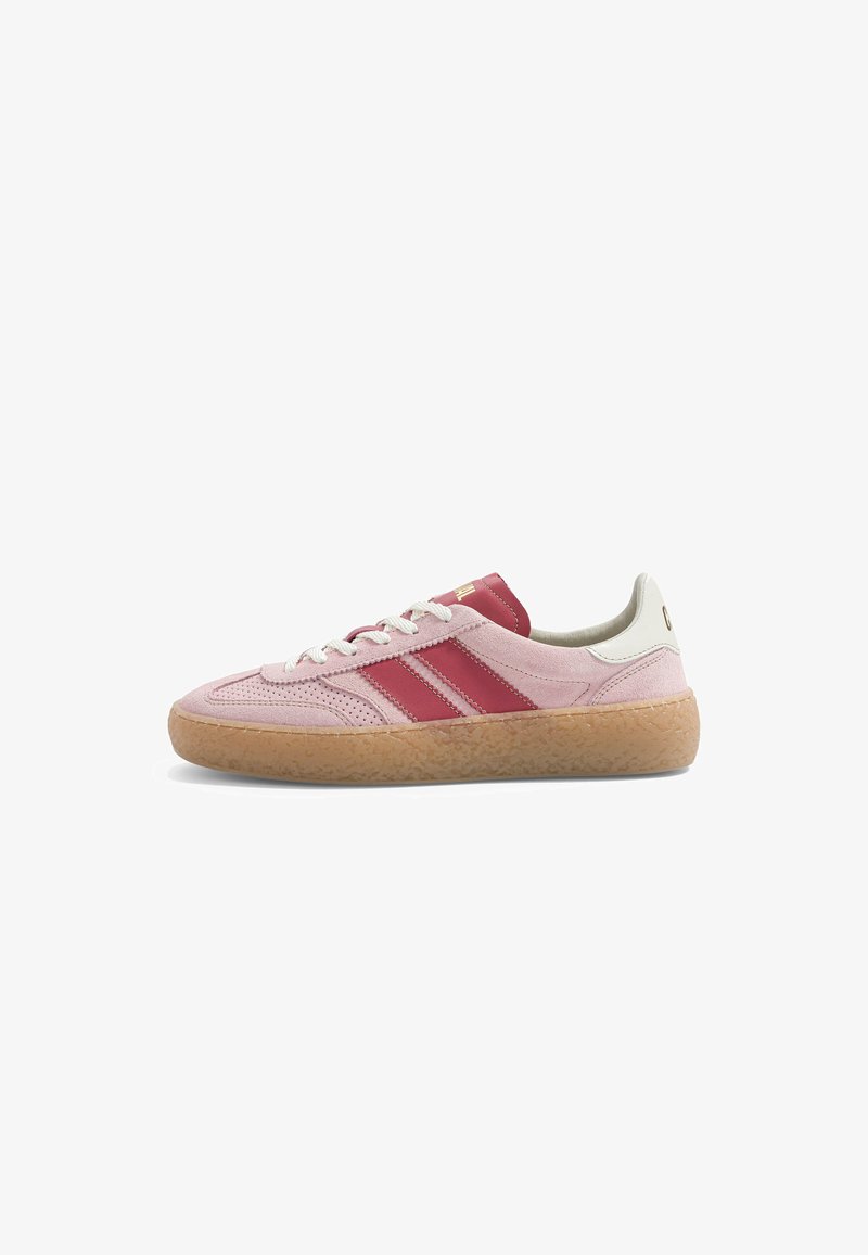 Baskets basses en daim rose avec des rayures rouges, des lacets blancs, une languette de talon blanche et une semelle en caoutchouc marron clair texturée.