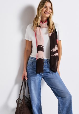 Donkerbruin en roze abstract patroon sjaal, gemaakt van lichte stof, gedragen met een witte top en blauwe wijde jeans. Geweven randen.
