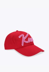 Cappellino da baseball rosso in cotone con visiera curva e testo ricamato rosa peloso "Kurt" sul davanti. Finitura testurizzata sulle lettere.