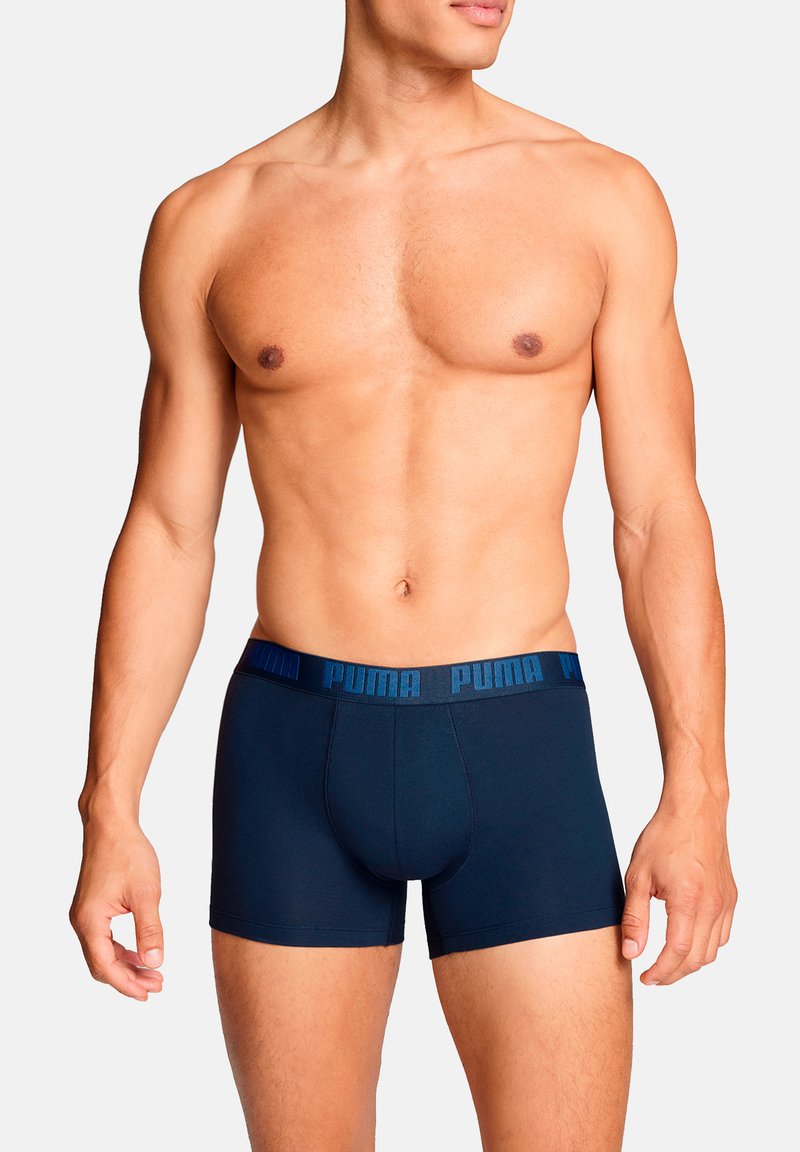 Marineblaue Boxershorts mit einem strukturierten Bund, der das "PUMA"-Logo in kontrastierendem Blau zeigt. Elastisches Material und figurbetontes Design.